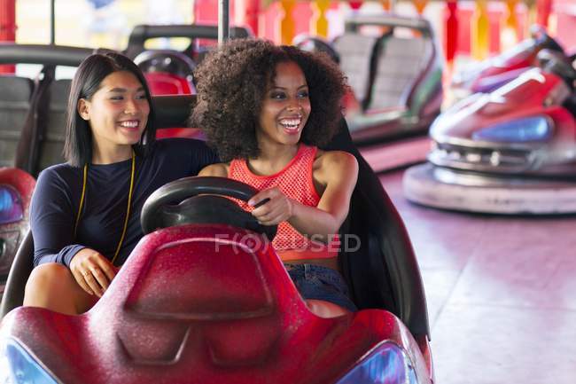 Zwei Frauen amüsieren sich auf Autoscooter. — Stockfoto