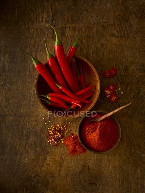 Fresh red chili peppers and powder, studio shot. — Stock Photo