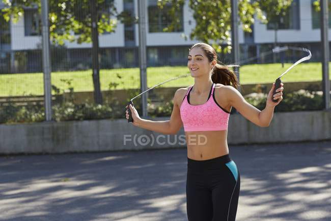 Young woman jumping with a skipping rope. — Stock Photo