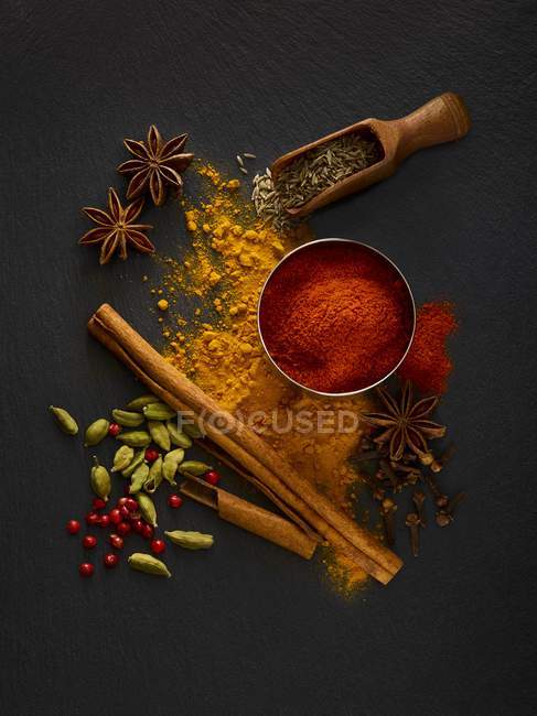 Dried spices on black slate, overhead view. — Stock Photo