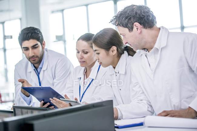 Colleghi medici che guardano clip board in discussione . — Foto stock