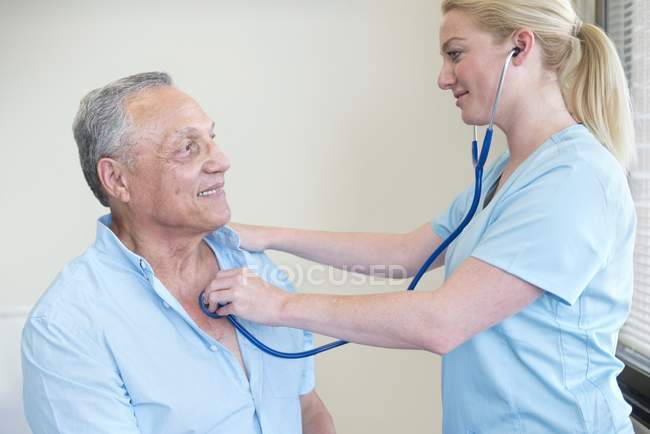 Ärztin untersucht Patientin mit Stethoskop. — Stockfoto