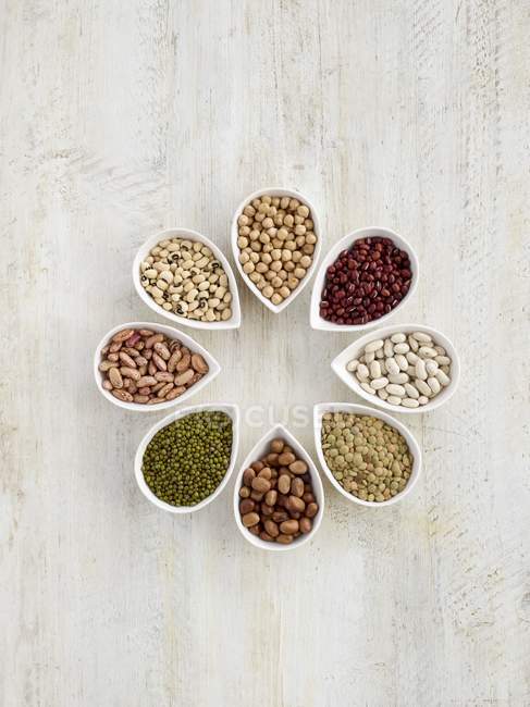 Pulses in tear shaped mini bowls, overhead view. — Stock Photo