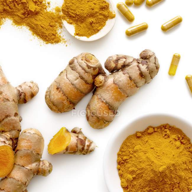 Turmeric root and powder in a bowl on white background. — Stock Photo