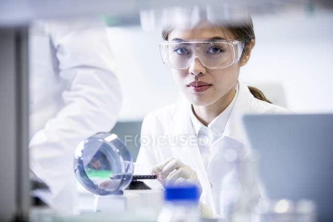 Asistente de laboratorio femenina usando mini centrifugadora
. - foto de stock