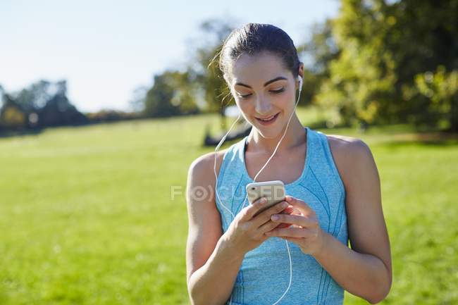 Jovem mulher ouvindo música no smartphone . — Fotografia de Stock