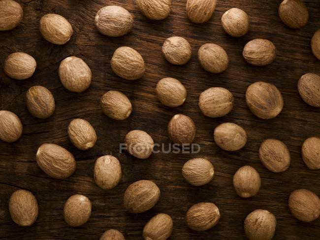 Nutmeg on wooden background, studio shot. — Stock Photo