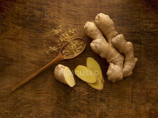 Ginger root and powder on wooden table, studio shot. — Stock Photo