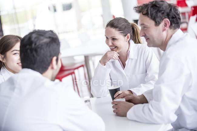Team of doctors resting in hospital canteen. — Stock Photo