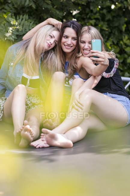 Tre donne che scattano selfie con smartphone . — Foto stock