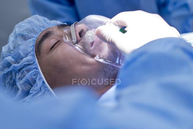 Paciente masculino en la mesa de operaciones con máscara de gas . - foto de stock