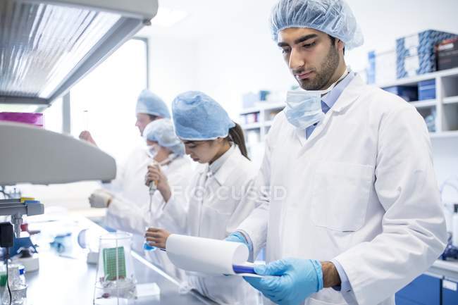 Ученые в защитной одежде работают в лаборатории
. — стоковое фото