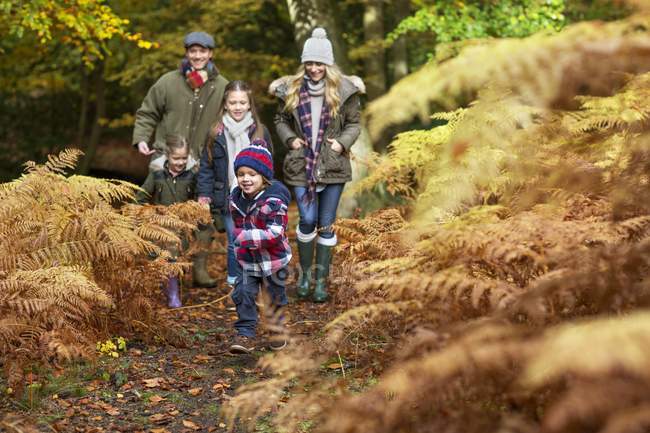 Family walking in autumnal forest. — Stock Photo