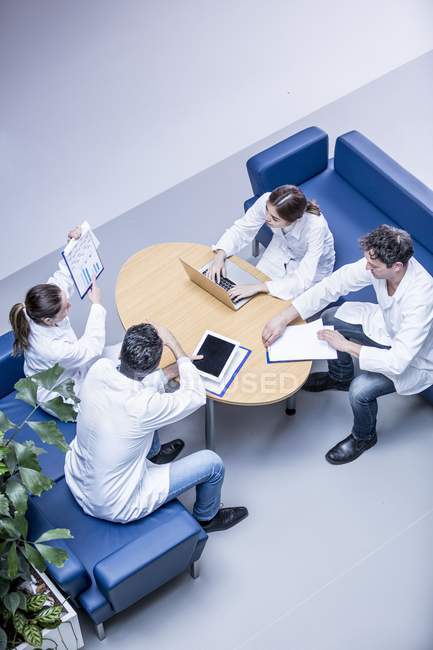 Команда лікарів обговорює роботу в лікарняному вестибюлі . — стокове фото