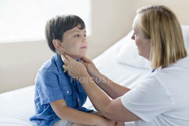 Enfermeira examinando glândulas de menino no hospital . — Fotografia de Stock