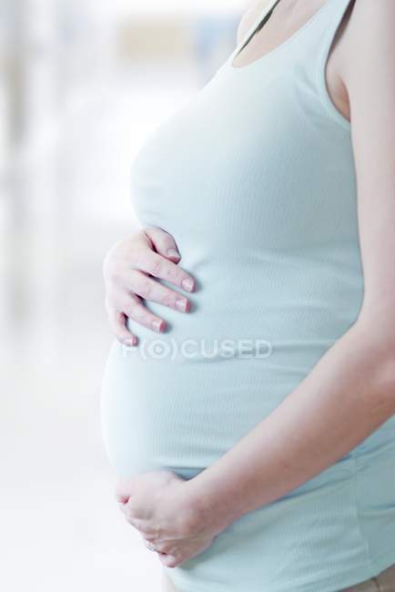 Femme enceinte avec les mains sur l'abdomen . — Photo de stock