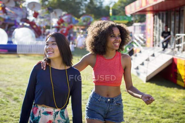 Deux jeunes femmes marchant à la fête foraine . — Photo de stock