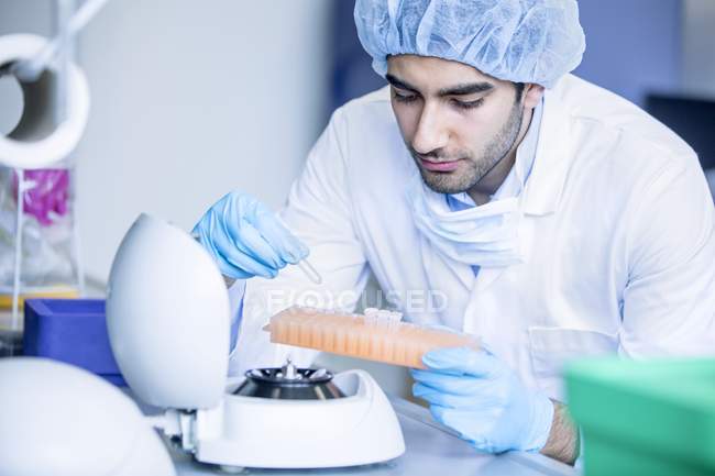 Hombre científico en ropa protectora trabajando en laboratorio
. - foto de stock