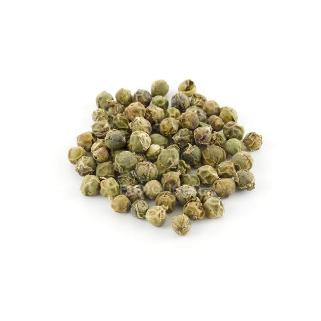 Pile de grains de poivre vert sur fond blanc . — Photo de stock