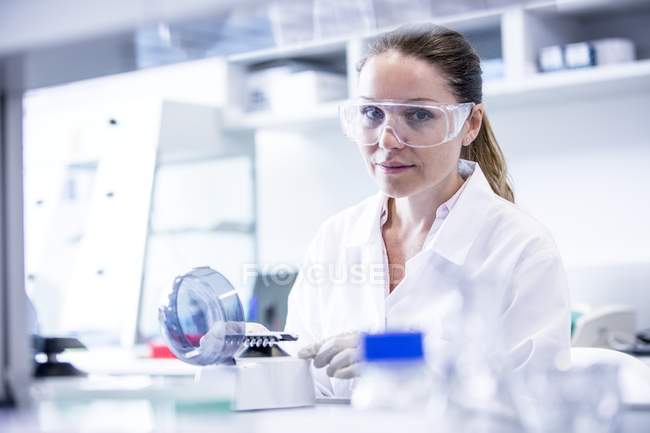 Female laboratory assistant using mini centrifuge. — Stock Photo