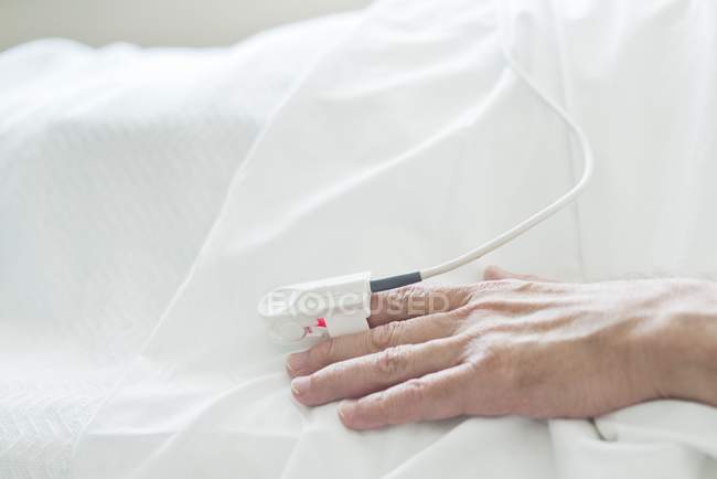 Patient hand with pulse oximeter, close-up. — Stock Photo