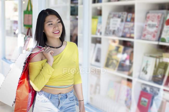 Asiático mulher andando passado livro loja janela . — Fotografia de Stock