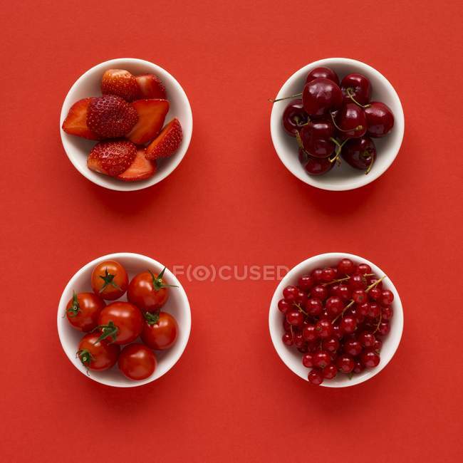 Productos rojos en platos sobre fondo rojo . - foto de stock