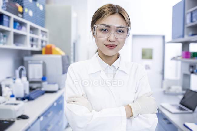 Assistente di laboratorio femminile in piedi con le braccia incrociate
. — Foto stock