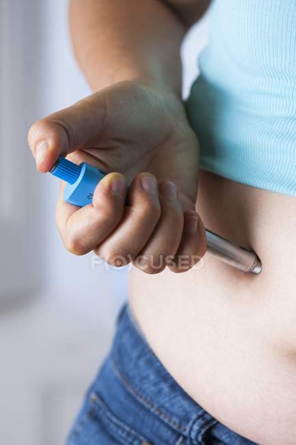 Female hand making injection in abdomen, close-up. — Stock Photo