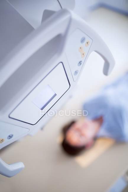 Máquina de raios X com paciente do sexo feminino deitado . — Fotografia de Stock