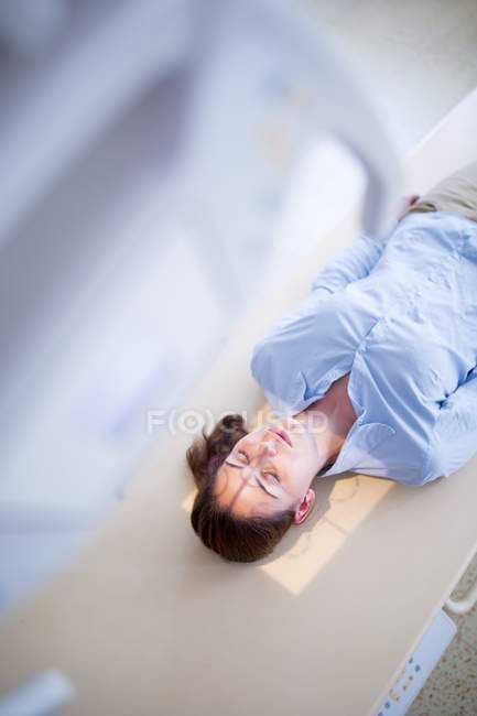 Patientin legt sich auf Röntgenbett. — Stockfoto