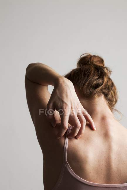 Frau kratzt juckenden Rücken, Rückansicht. — Stockfoto