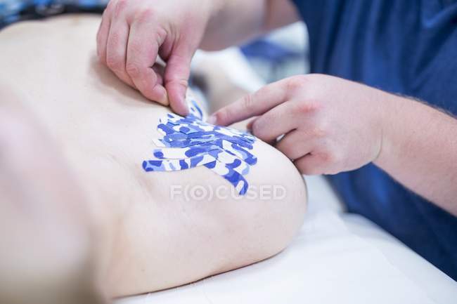 Doctor applying plasters to patient shoulder, close-up. — Stock Photo