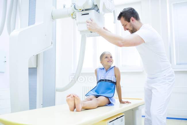 Doctor preparing young girl for x-ray in hospital. — Stock Photo