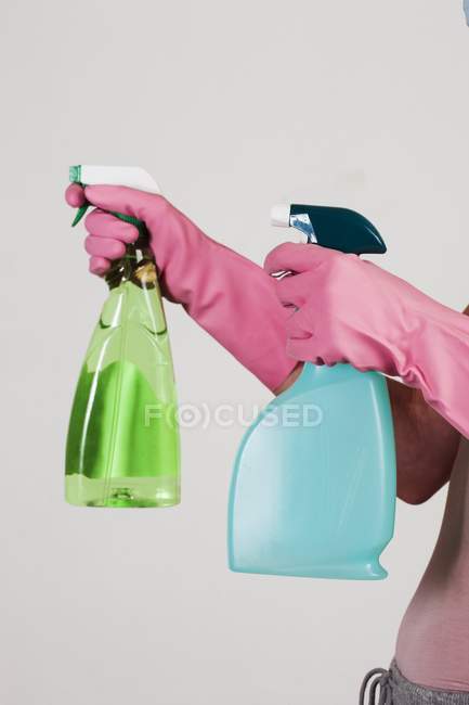 Nahaufnahme der Hände mit rosa Handschuhen, die Reinigungsmittel enthalten. — Stockfoto