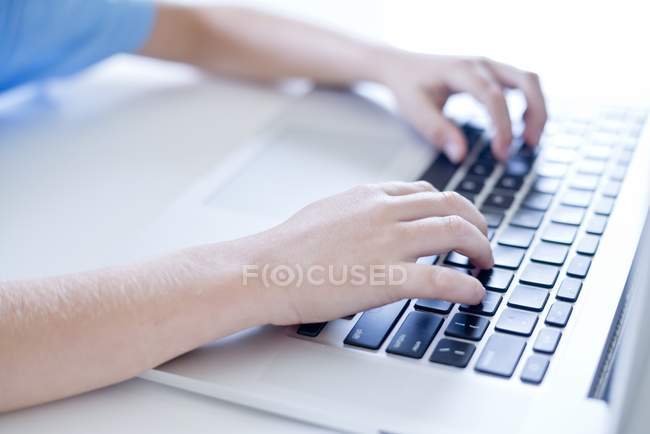 Nahaufnahme von Jungenhänden mittels Laptop-Tastatur. — Stockfoto