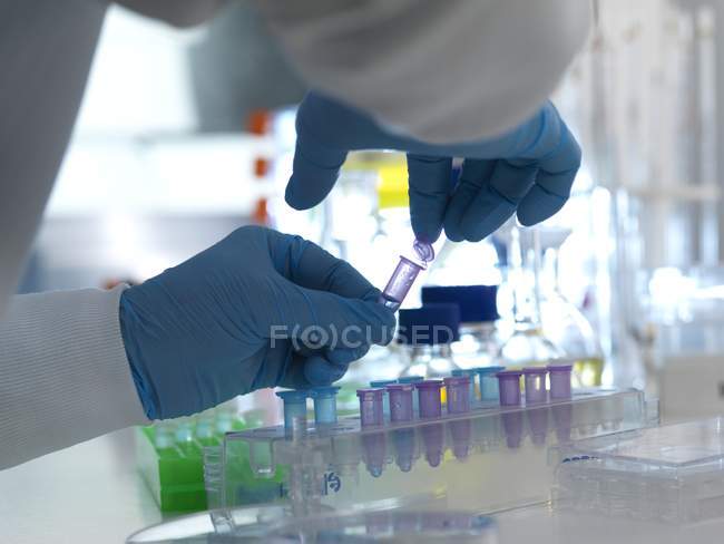 Scientist closing lid of vial while laboratory testing. — Stock Photo