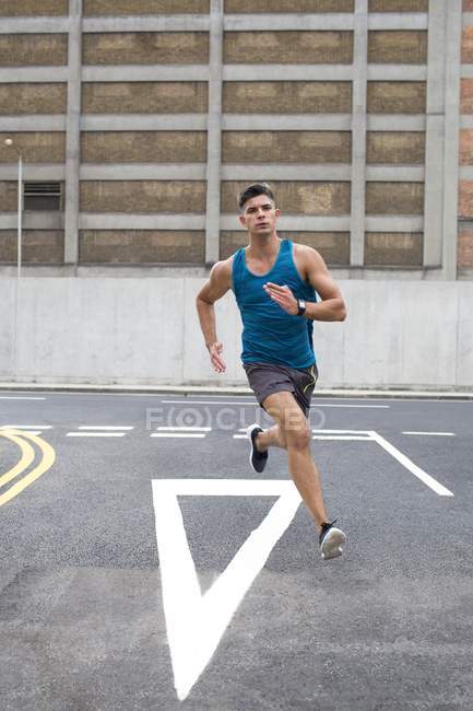 Mann in Sportkleidung läuft auf Straße. — Stockfoto