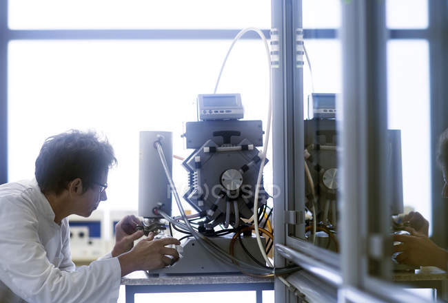 Chemist setting up vacuum pump in pharmaceutical laboratory. — Stock Photo