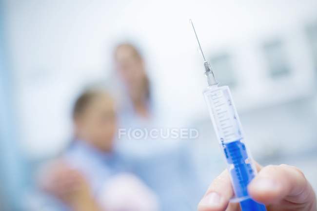 Hand holding injection syringe, close-up. — Stock Photo