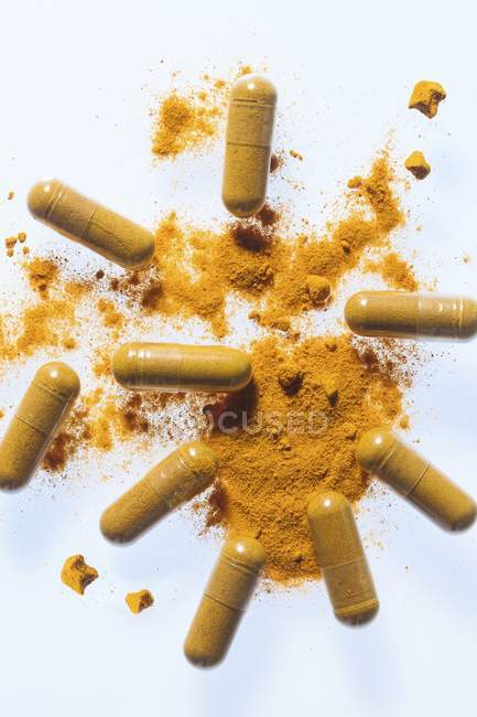 Turmeric supplement capsules and powder, studio shot. — Stock Photo