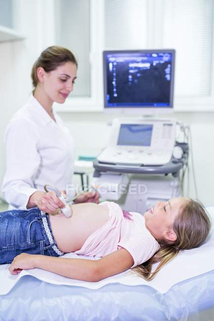 Sonógrafo realizando ultrasonido en vientre de niña . - foto de stock
