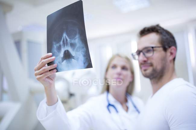Médecins tenant une radiographie du crâne humain . — Photo de stock