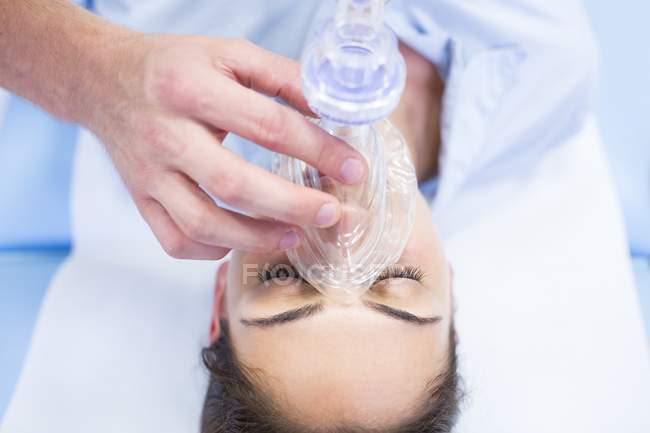 Young woman with resuscitation mask and male hand. — Stock Photo