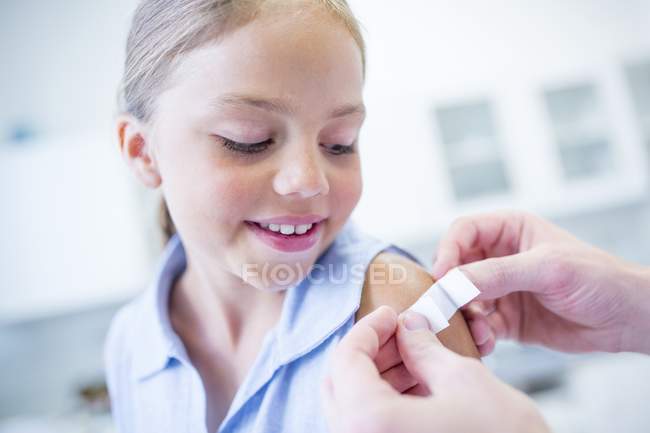 Pessoa aplicando gesso para jovem ombro menina — Fotografia de Stock