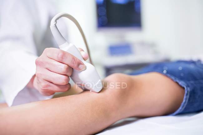 Sonographer performing ultrasound on child leg, close-up. — Stock Photo