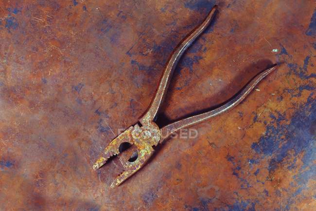 Old pliers on rusty background, close-up. — Stock Photo