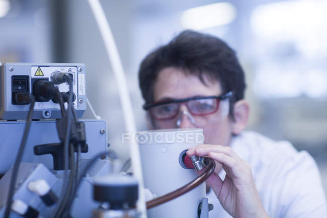 Женщина-химик устанавливает вакуумный насос в лаборатории, крупным планом — стоковое фото