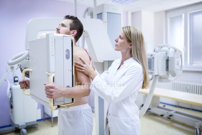 Жінка-лікар вивчає чоловічі груди з рентгенівським випромінюванням . — стокове фото