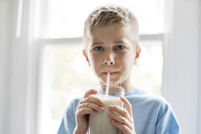 П'ятнадцять хлопчиків п'ють молочний коктейль з питною соломою — стокове фото